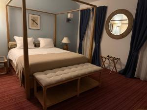 a bedroom with a canopy bed and a mirror at Les chambres du Domaine Rollan de By in Bégadan