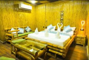 a bedroom with a large bed and two chairs at Hotel First Impression in Rāmnagar