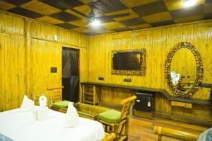 a room with two beds and a mirror and a tv at Hotel First Impression in Rāmnagar