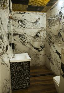 a bathroom with a black and white marble wall at Hotel First Impression in Rāmnagar +25 photos