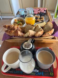 a table with a tray of bread and a plate of coffee at Caza Bodo in Sausset-les-Pins