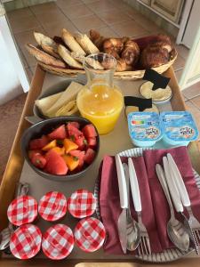 a table topped with a tray of food with a bowl of fruit at Caza Bodo in Sausset-les-Pins +16 photos
