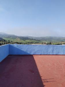 a view from the roof of a house with a blue wall at Maison d'hôte Yeswal in Guezira