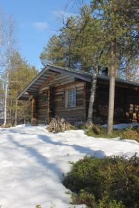 a log cabin with snow in front of it at River Cabin Urpo in Inari +9 photos