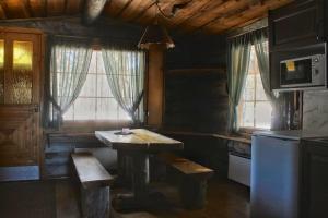 a kitchen with a wooden table and a refrigerator at River Cabin Urpo in Inari