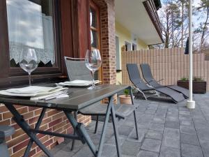 a table and chairs on a patio with wine glasses at Helena Ferienwohnung in Hemfurth-Edersee