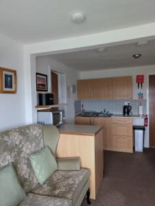 a living room with a couch and a kitchen at Scoor House - Cnoc Mor in Bunessan