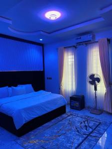 a bedroom with a bed and a blue ceiling at King Arthur Apartment in Akwa
