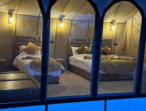 two beds in a room with a mirror at Grand Dunes Luxury Camp in Merzouga +10 photos