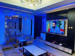 a living room with a large screen television at King Arthur Apartment in Akwa