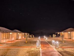 a group of tents at night with lights at Grand Dunes Luxury Camp in Merzouga