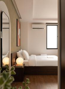 a bedroom with a white bed and a mirror at V Living - Downtown Saigon Stay with Free Laundry in Ho Chi Minh City