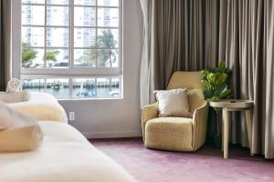 a hotel room with a chair and a window at Alamo Hotel in Miami Beach