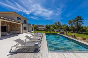 a villa with a swimming pool and lounge chairs at Villa Adeona in Zonza