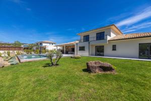 a house with a yard with a rock at Villa Adeona in Zonza