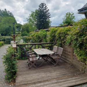 a picnic table and two chairs on a wooden deck at Green Acres Bretagne in Maël-Carhaix