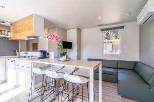 a kitchen with a table and stools at Camping Valras plage 5 étoiles in Vendres