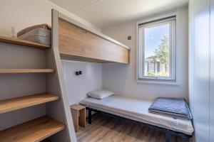a small room with a bunk bed and a window at Camping Valras plage 5 étoiles in Vendres +24 photos