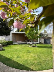 a house with a garden with a bench and pink flowers at Penzion Lívanec in Horní Bezděkov