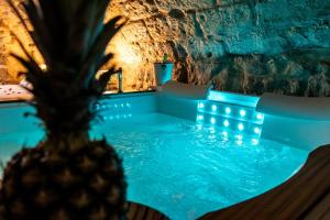 a hot tub in a cave with blue lighting at Dimora Don Gabriele e Suite in Mola di Bari