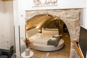 a bedroom with a bed in a stone wall at Dimora Don Gabriele e Suite in Mola di Bari +60 photos