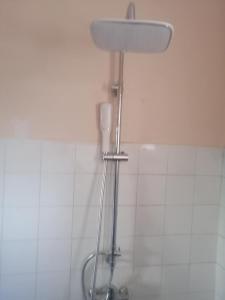 a shower in a bathroom with a white tiled wall at iomnium in Tigzirt