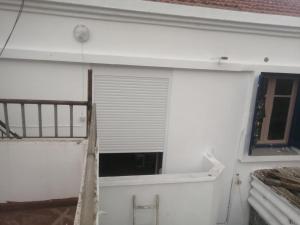 a window in the side of a white building at iomnium in Tigzirt