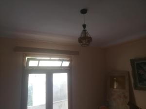 a room with a window and a light fixture at iomnium in Tigzirt