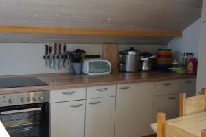 a kitchen with white cabinets and a counter top at IškAAdventure-appertment in Ig +18 photos