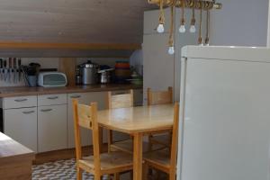 a kitchen with a wooden table and a refrigerator at IškAAdventure-appertment in Ig
