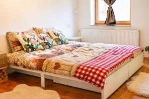 a bedroom with a bed with a checkered blanket at IškAAdventure-appertment in Ig