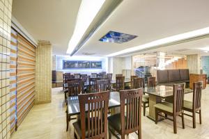 a dining room with tables and chairs in a restaurant at Hotel Mayur in New Delhi
