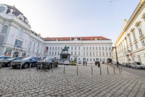 a large building with cars parked in the middle of a street at Jela`s Suite in Vienna +1 photo