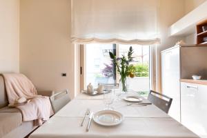 a dining room with a table and a large window at Residence Verdeluna in Marina di Pietrasanta