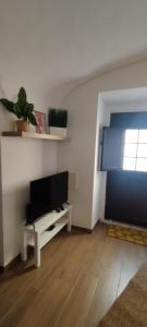 a living room with a flat screen tv on a white wall at Casa da Capinha Rota - Moura in Moura