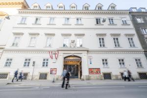 a white building with people bicycling in front of it at Jela`s Suite in Vienna