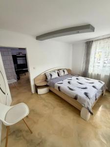 ein Schlafzimmer mit einem Bett und einem Stuhl in der Unterkunft La DeDe in Calafat
