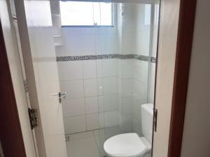 a small bathroom with a toilet and a shower at Apartamento 70 metros do mar in Florianópolis