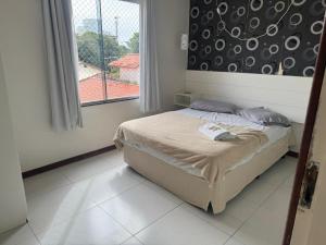 a bedroom with a bed and a large window at Apartamento 70 metros do mar in Florianópolis