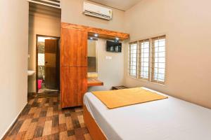 a bedroom with a bed and a window at RAGAM RESORT in Alleppey