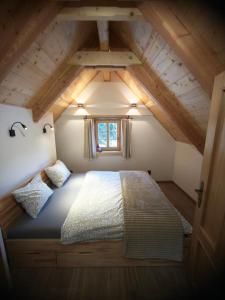 a bedroom with a large bed in a attic at Roubenka a miniroubenka, Olšany in Olšany
