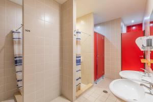 a bathroom with two sinks and a red door at HI Tavira – Pousada de Juventude in Tavira +28 photos