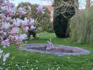 a statue of a bunny sitting in a fountain in a yard at Solvang in Assens