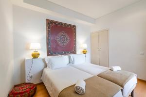 a bedroom with a large bed and a painting on the wall at HI Tavira – Pousada de Juventude in Tavira