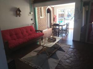 a living room with a red couch and a table at Posada del Baradero in Baradero