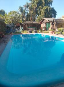 a large swimming pool with blue water in front of a house at Posada del Baradero in Baradero +17 photos