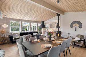 a dining room and living room with a table and chairs at OH585-Hadsund-Brondbaekken-34 in Øster Hurup