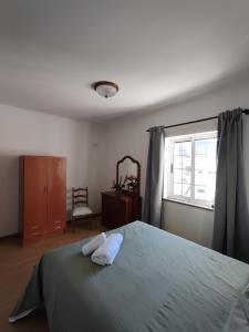 a bedroom with a bed and a window and a chair at Alojamento Local Velas Balcony in Velas