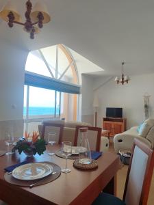 a living room with a table and a room with a window at Alojamento Local Velas Balcony in Velas