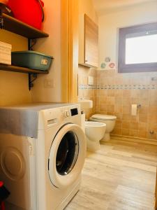 a washing machine in a bathroom with a toilet at Sardegna selvaggia a due passi dal mare in Vignola Mare